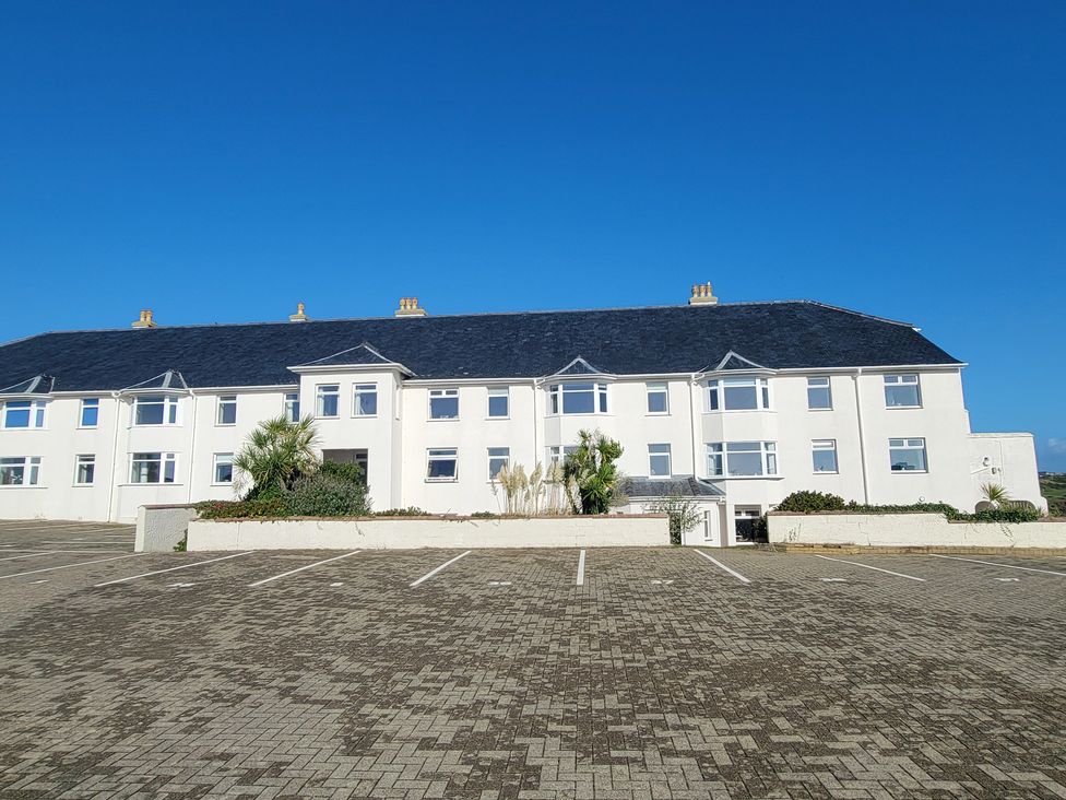 A building exterior with windows and parking spaces at Plas Darien no 28 Trearddur Bay