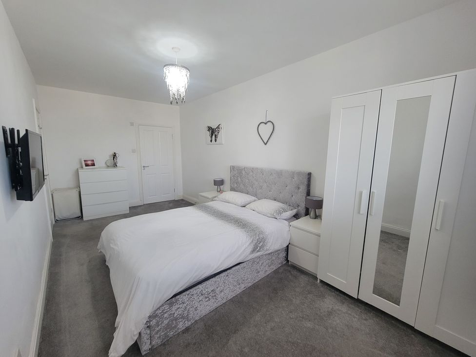 A bedroom with a bed and wardrobe at Plas Darien no 28 Trearddur Bay