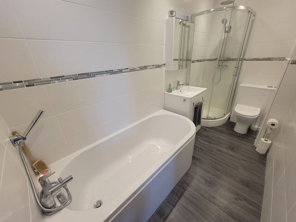 A bathroom with a shower and bathtub at Plas Darien no 28 Trearddur Bay