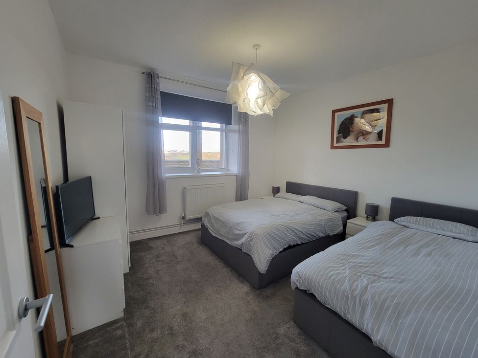 A bedroom with two beds and a television at Plas Darien no 28 Trearddur Bay