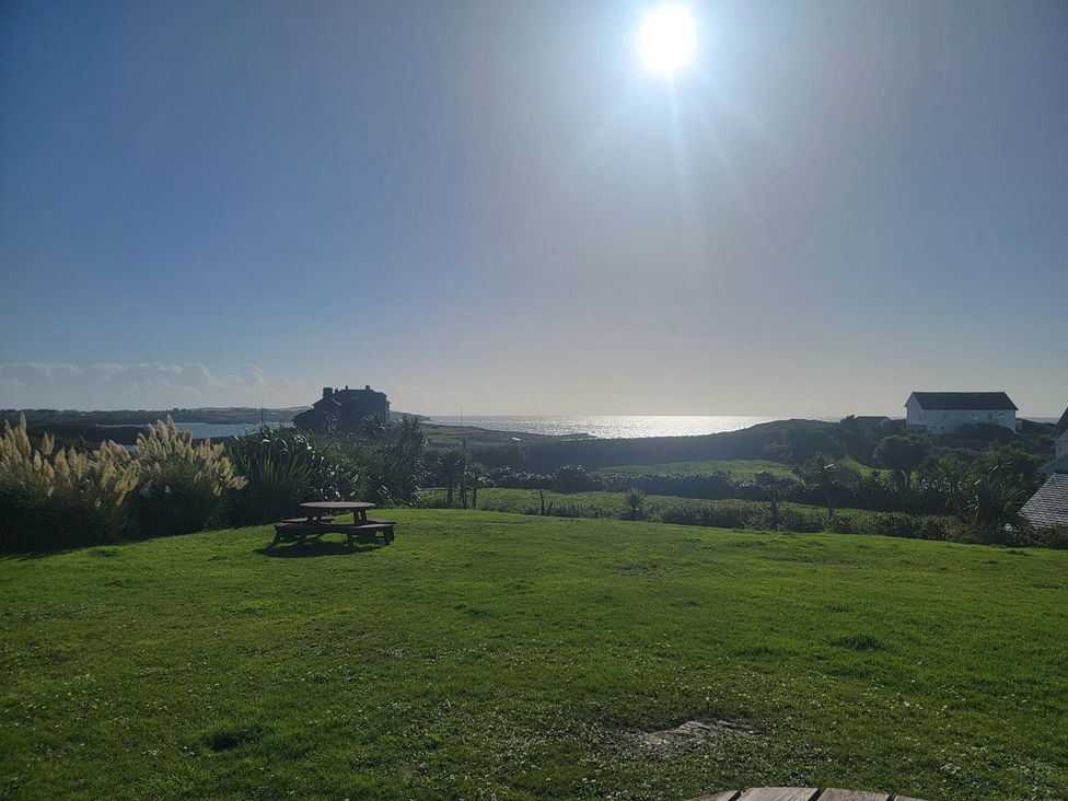 A garden with a picnic table and sea view at Plas Darien no 28 Trearddur Bay