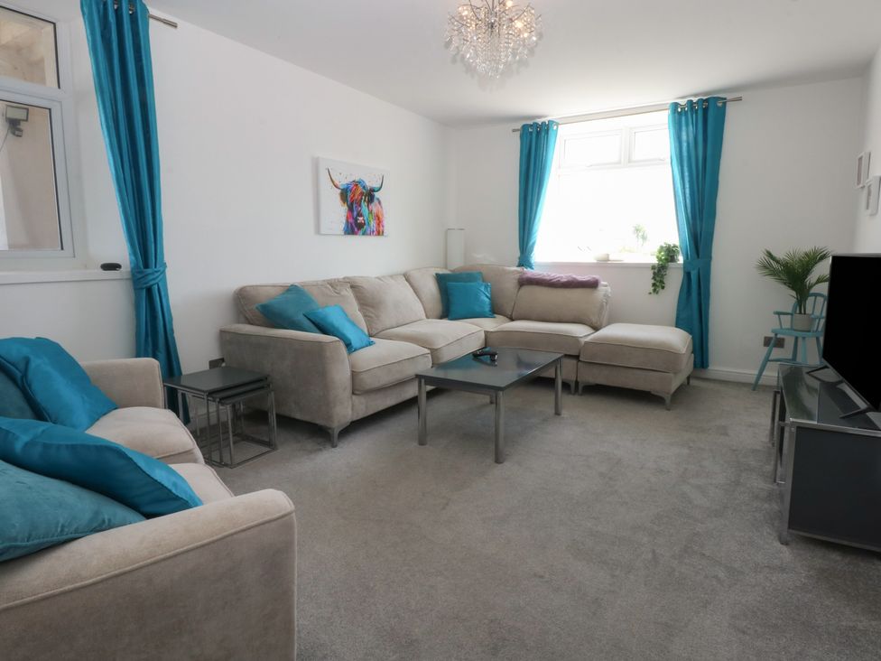 A living room with a sofa and coffee table at Cwtch y Môr Trearddur Bay