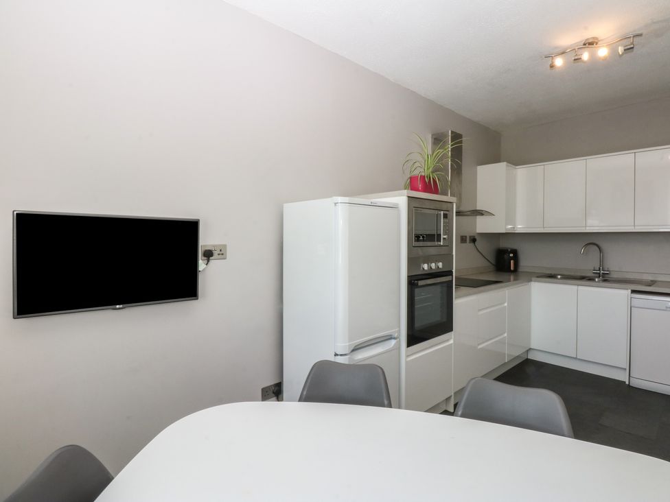 A kitchen with a refrigerator and oven at Cwtch y Môr Trearddur Bay