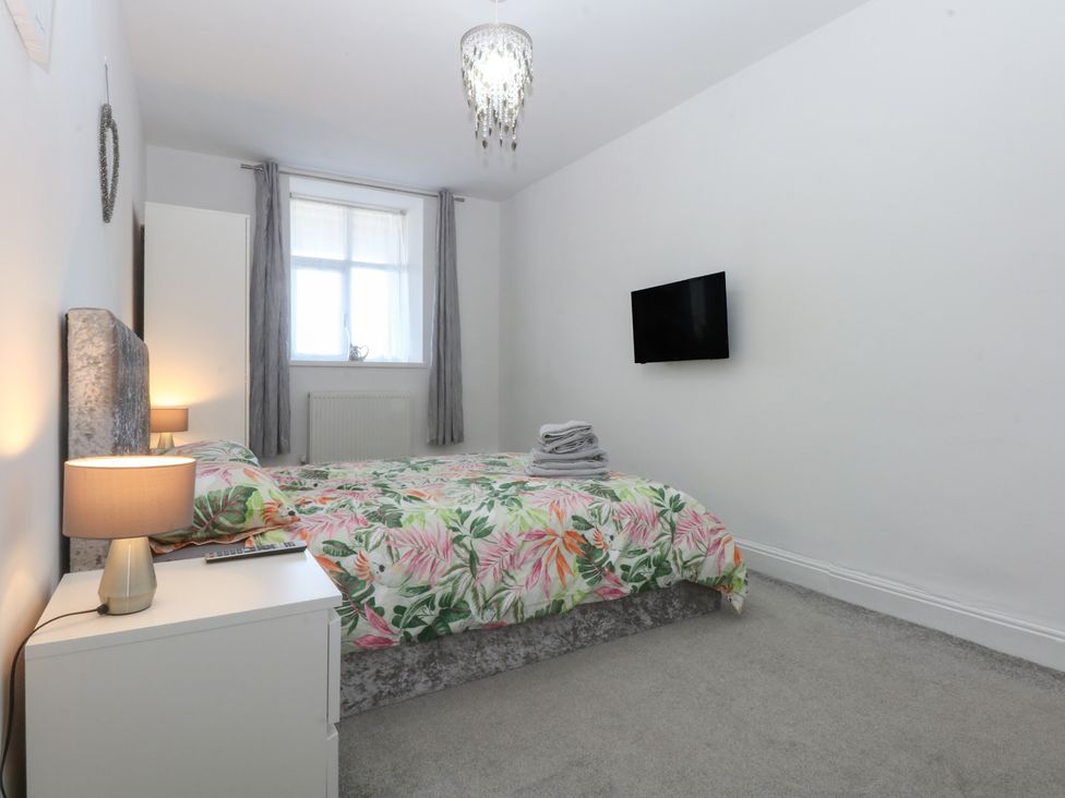 A bedroom with a bed and television at Cwtch y Môr in Trearddur Bay