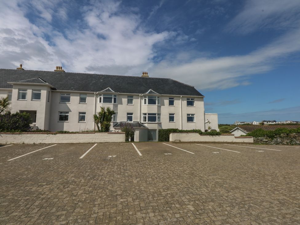 A house with a parking lot and plants at Cwtch y Môr in Trearddur Bay