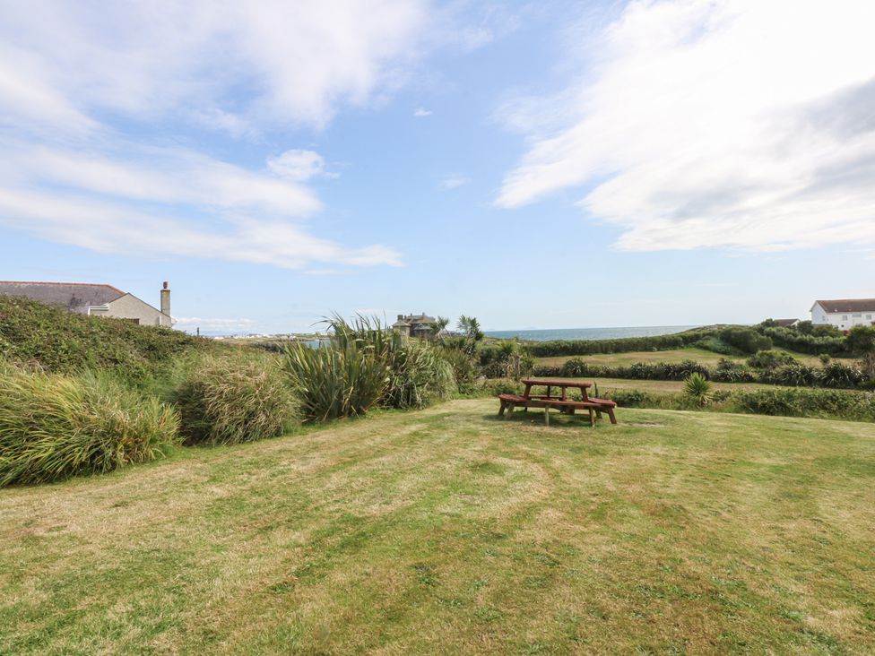 An outdoor space with a picnic table and grass at Cwtch y Môr Trearddur Bay