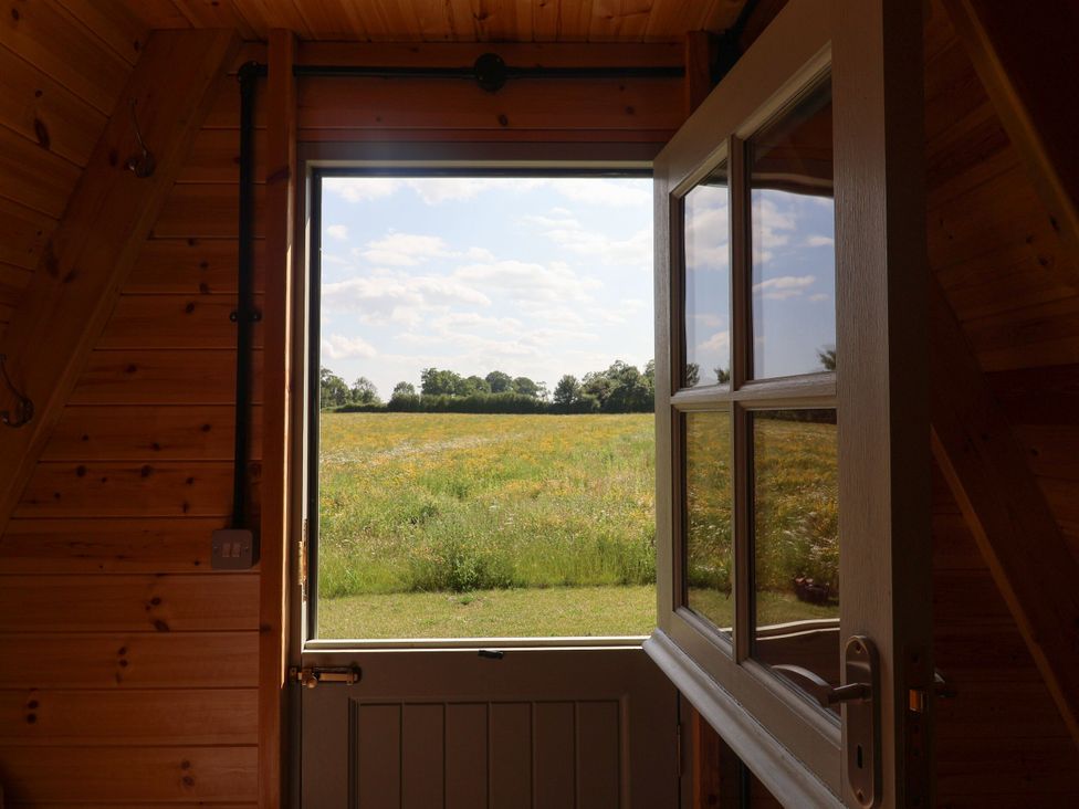 A view through an open door looking at a grassy field and trees at 1 Bed Sleeps 2, Shared Bathroom Monewden near Otley, Suffolk