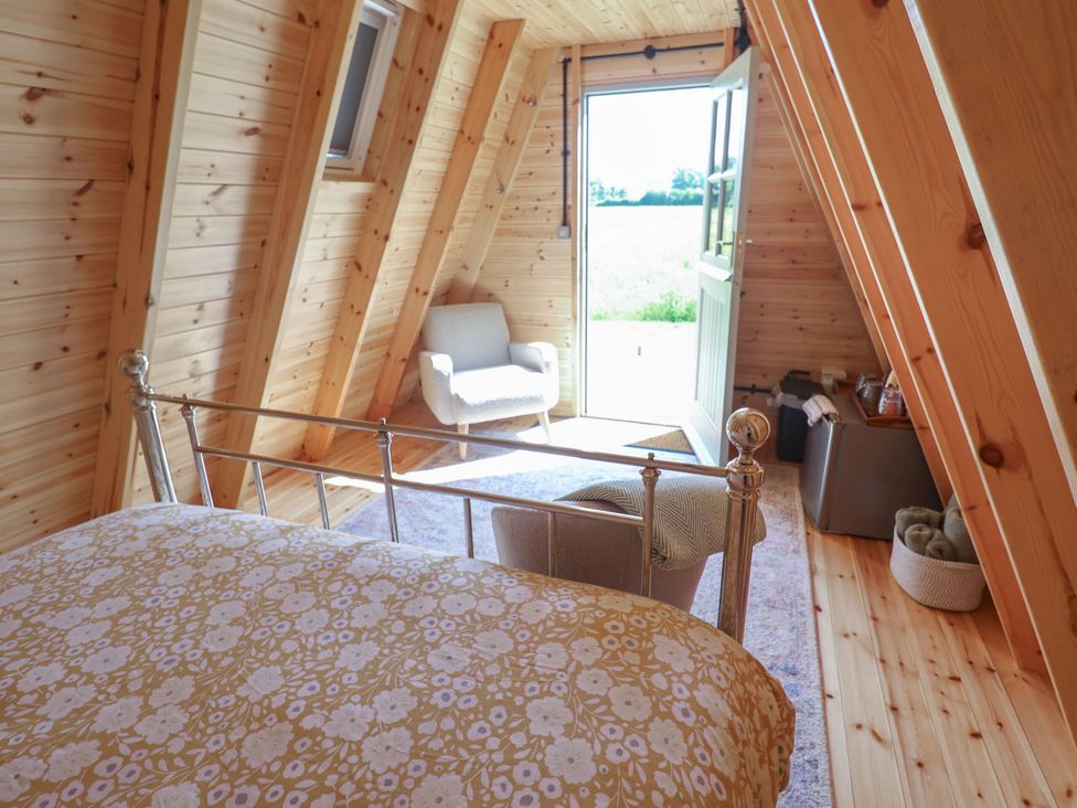 A bedroom with a bed and armchair at 1 Bed Sleeps 2, Shared Bathroom in Monewden near Otley, Suffolk