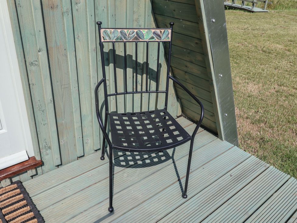 A chair positioned on a wooden deck at 1 Bed Sleeps 2, Shared Bathroom Monewden near Otley, Suffolk