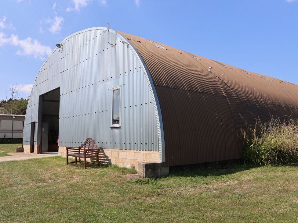 A metal building with a bench in front at 1 Bed Sleeps 2, Shared Bathroom, Monewden near Otley, Suffolk