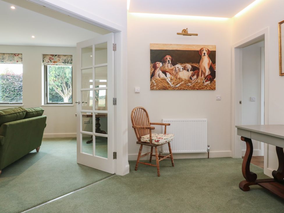 A living room with a green sofa and a painting at Lower Lodge Cupar