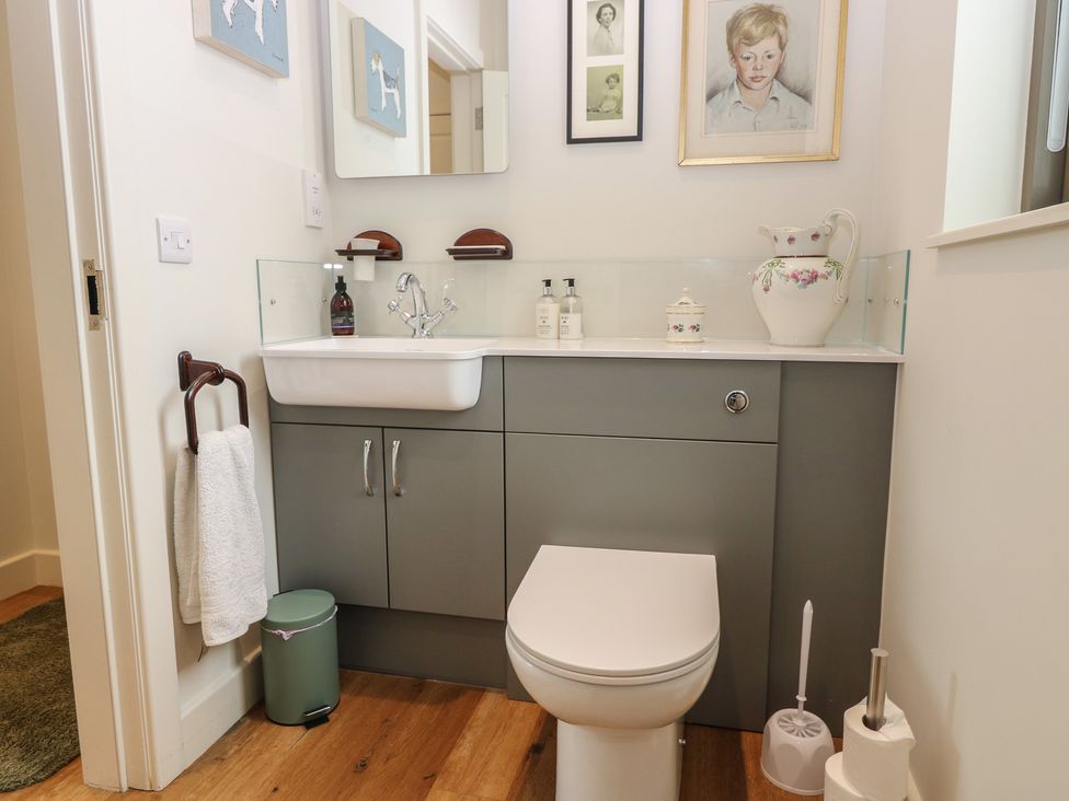 A bathroom with a sink, toilet, and storage cabinet at Lower Lodge Cupar