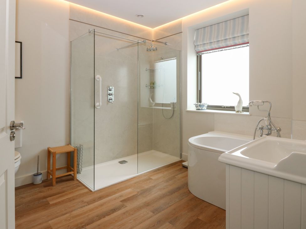 A bathroom with a shower, bathtub, sink, and toilet at Lower Lodge in Cupar