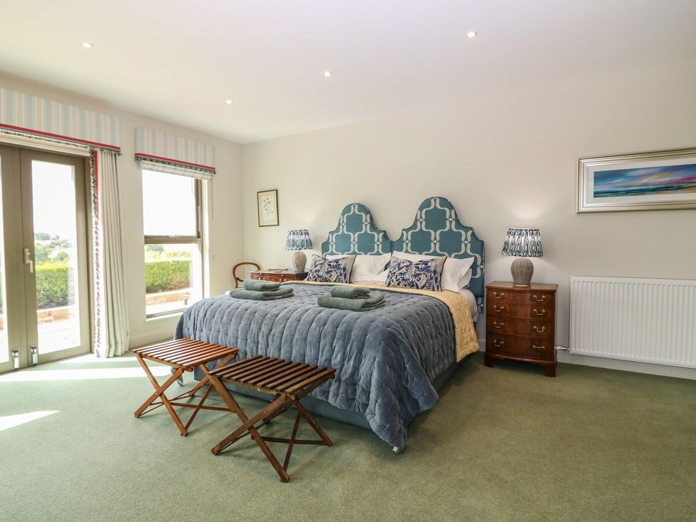 A bedroom with a large bed and bedside table at Lower Lodge in Cupar