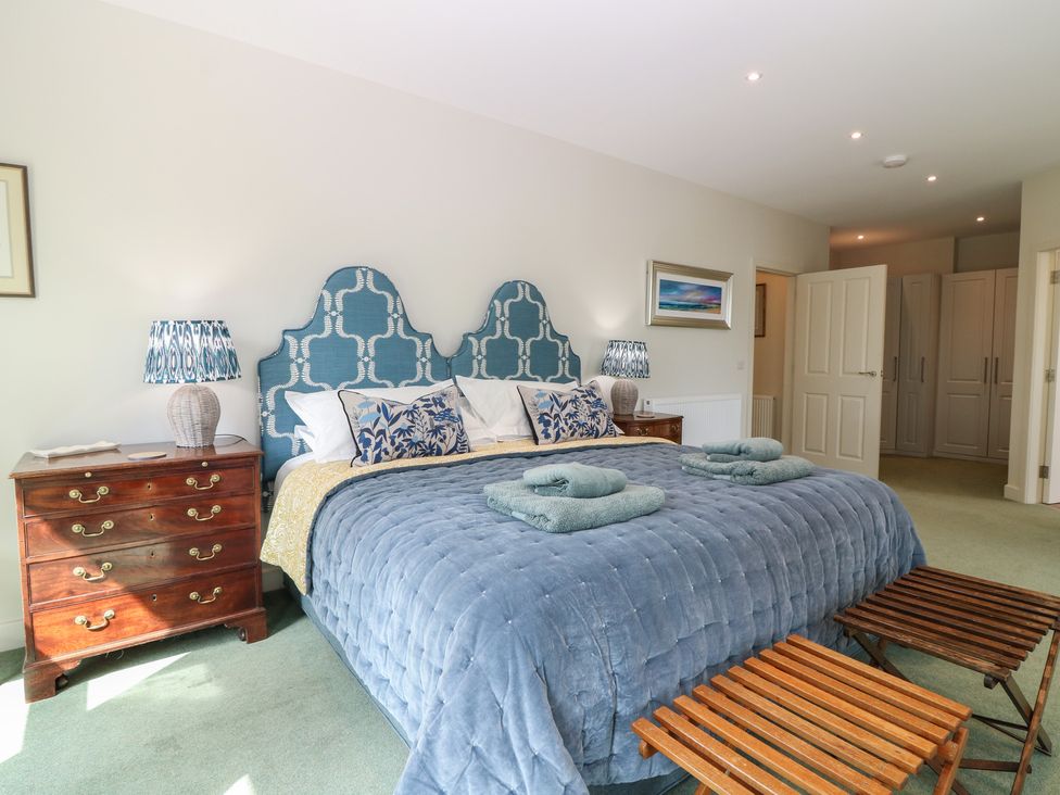 A bedroom with a large bed and bedside table at Lower Lodge in Cupar