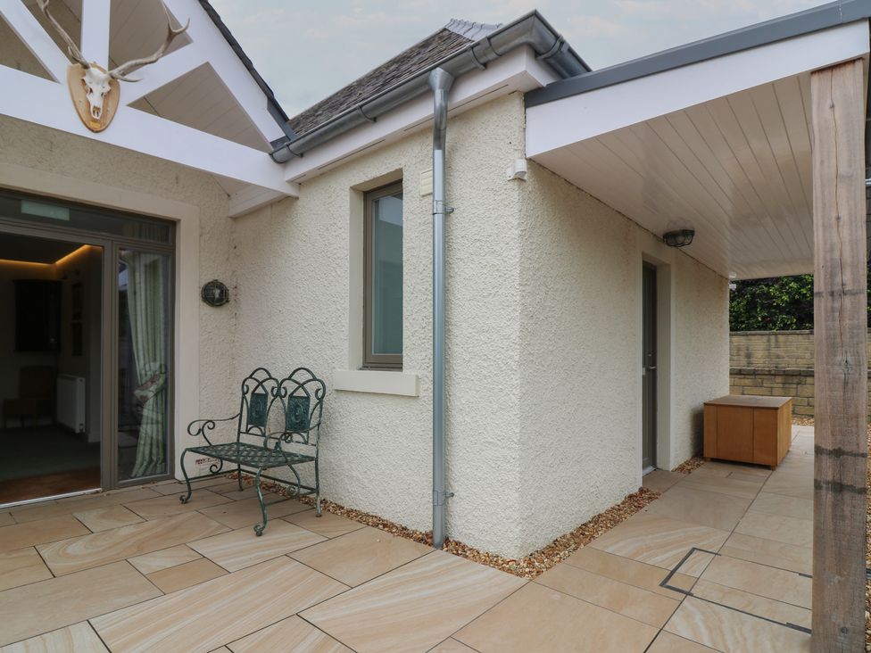 An outdoor patio with seating and a door at Lower Lodge in Cupar