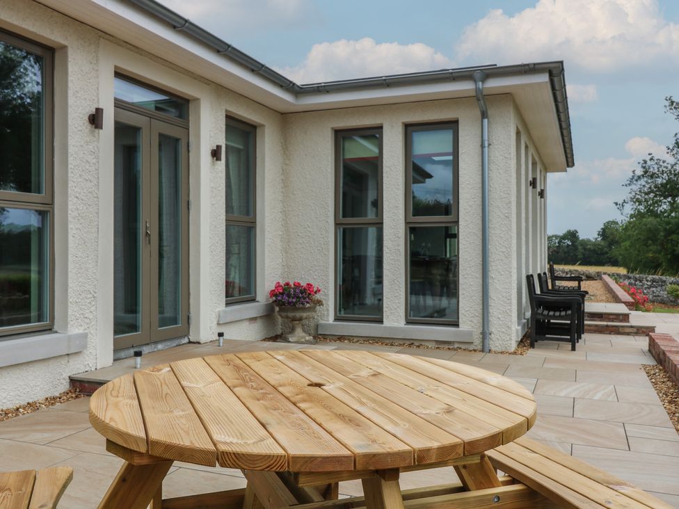 An outdoor area with a wooden table and chairs at Lower Lodge in Cupar