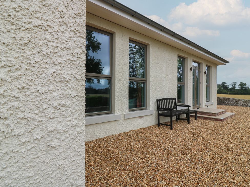An outdoor area with a bench and gravel at Lower Lodge in Cupar