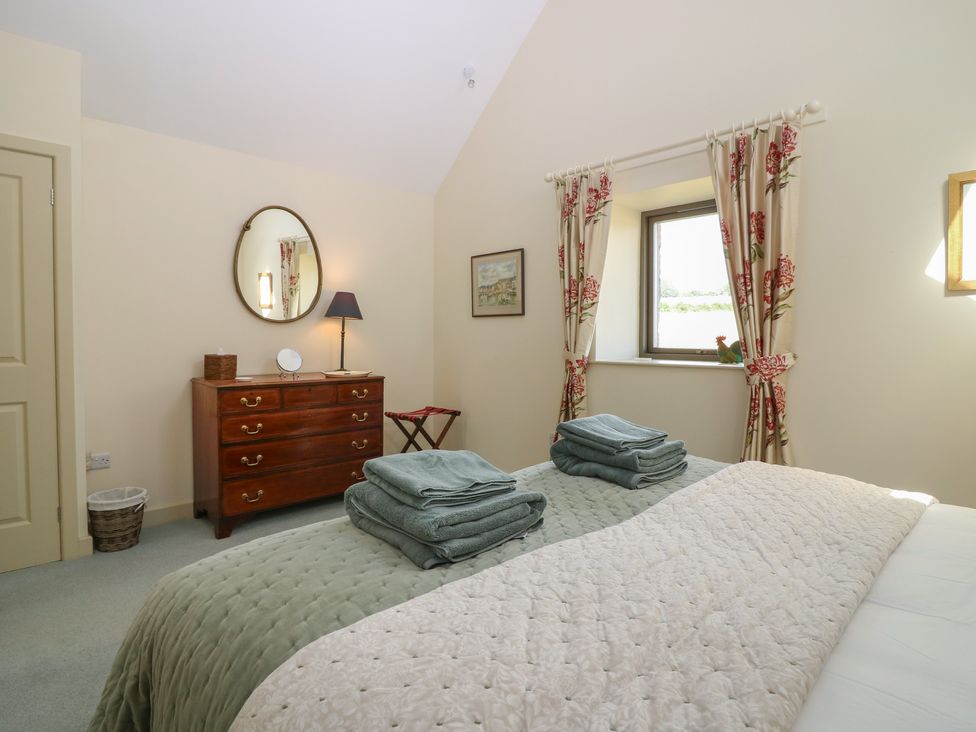 A bedroom with a bed and furniture at The Barn, Lower Lodge in Cupar