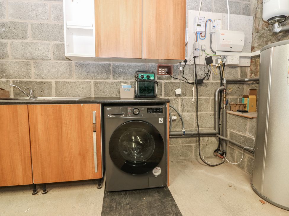 A laundry room with a washer and sink at The Barn, Lower Lodge Cupar