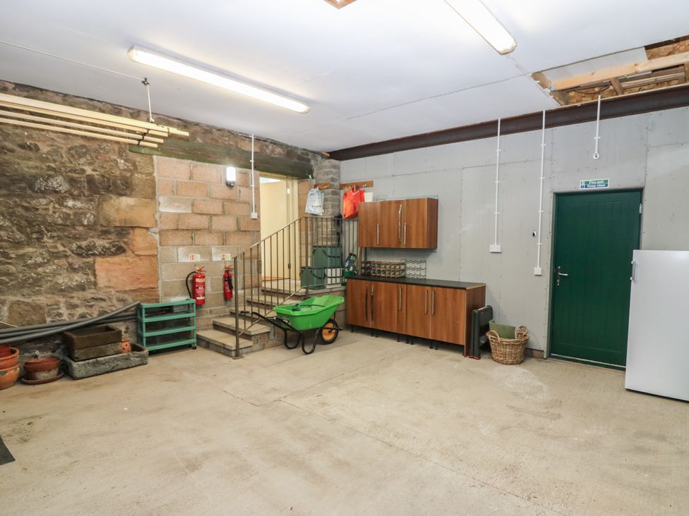 A garage with storage and a staircase at The Barn, Lower Lodge Cupar