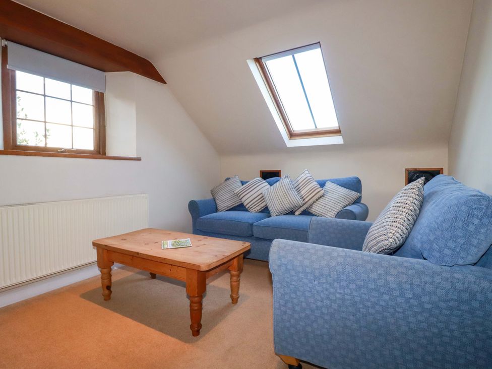 A living room with a sofa and coffee table at The Stables in Falmouth
