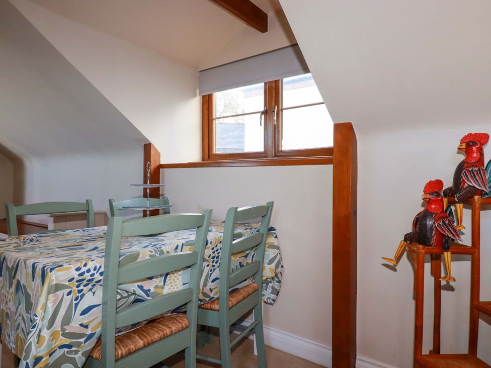A dining room with a table and chairs at The Stables in Falmouth