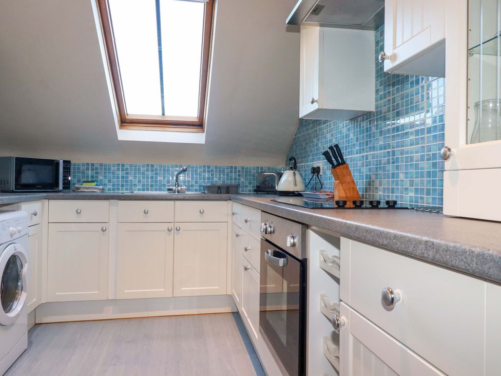 A kitchen with appliances and a window at The Stables in Falmouth