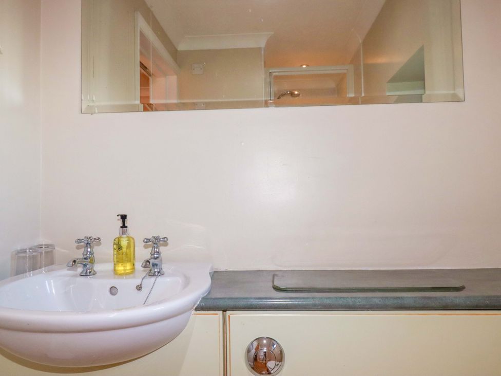 A bathroom sink with faucets and soap dispenser at The Stables in Falmouth