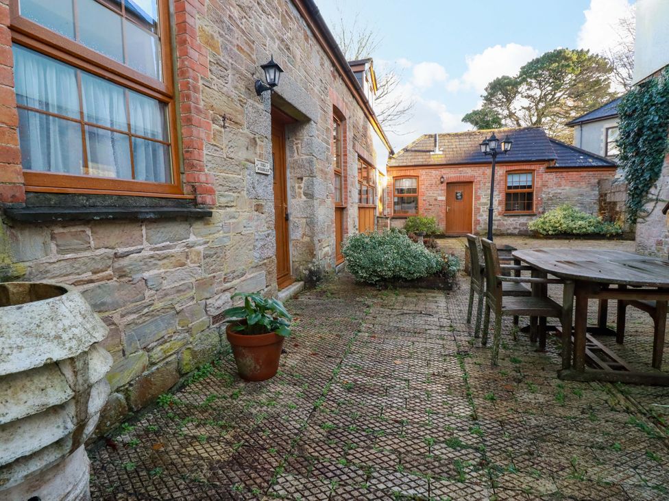 An outdoor seating area with a table and chairs at The Stables in Falmouth