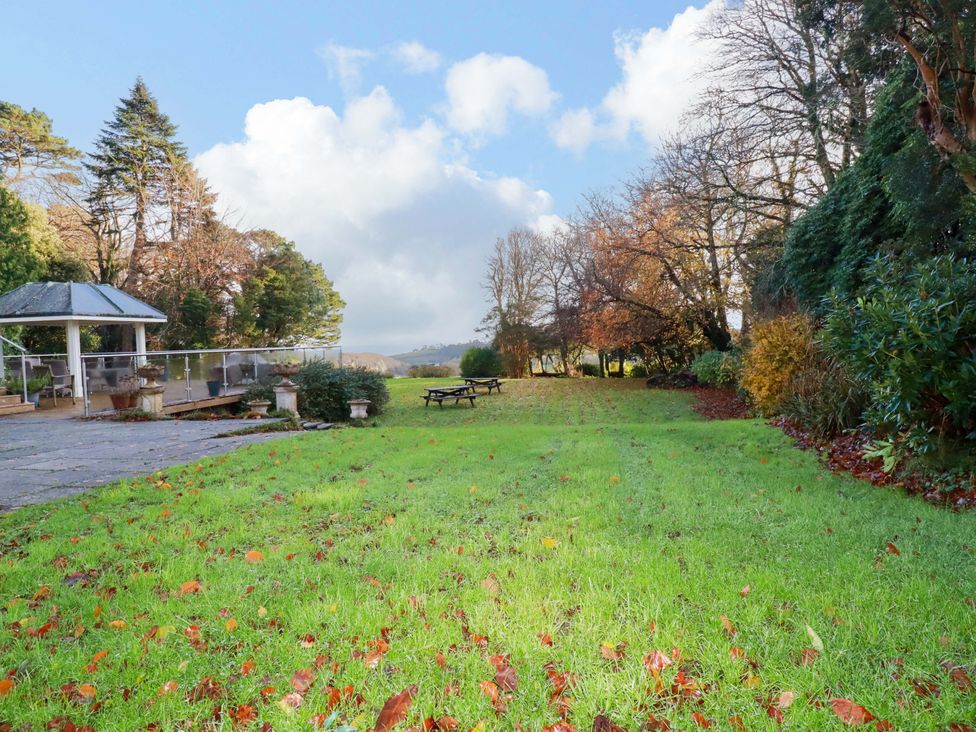 A garden with grass and trees at The Stables in Falmouth