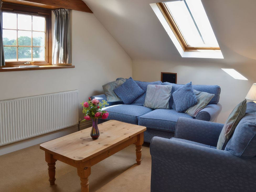 A snug with a sofa and coffee table at The Stables Budock Water near Falmouth