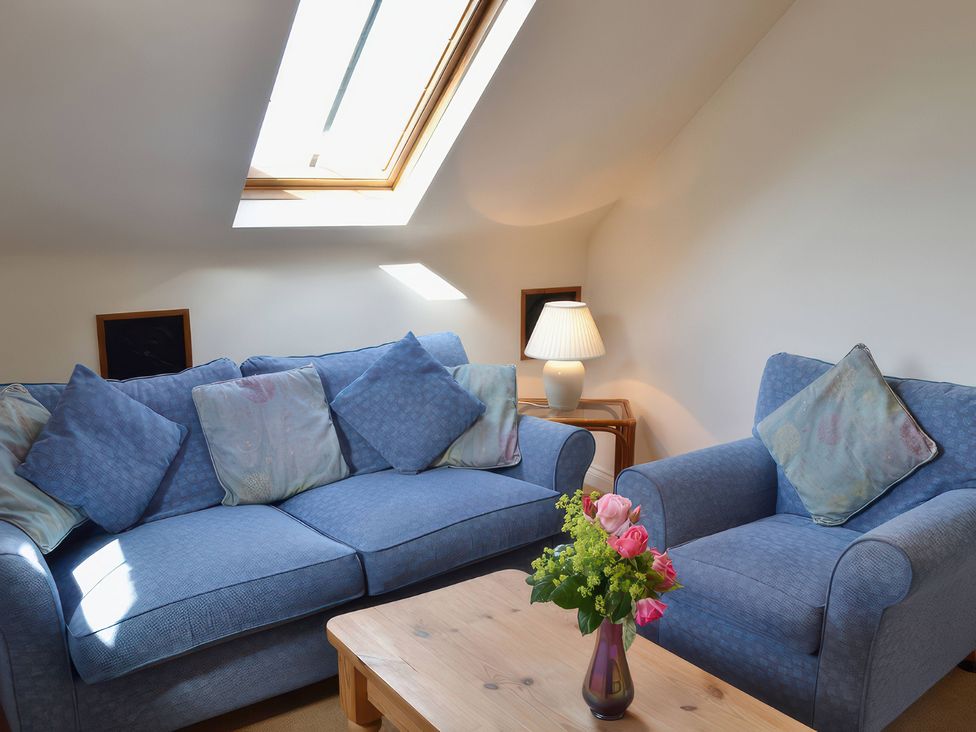 A living room with a sofa and armchair at The Stables Budock Water near Falmouth