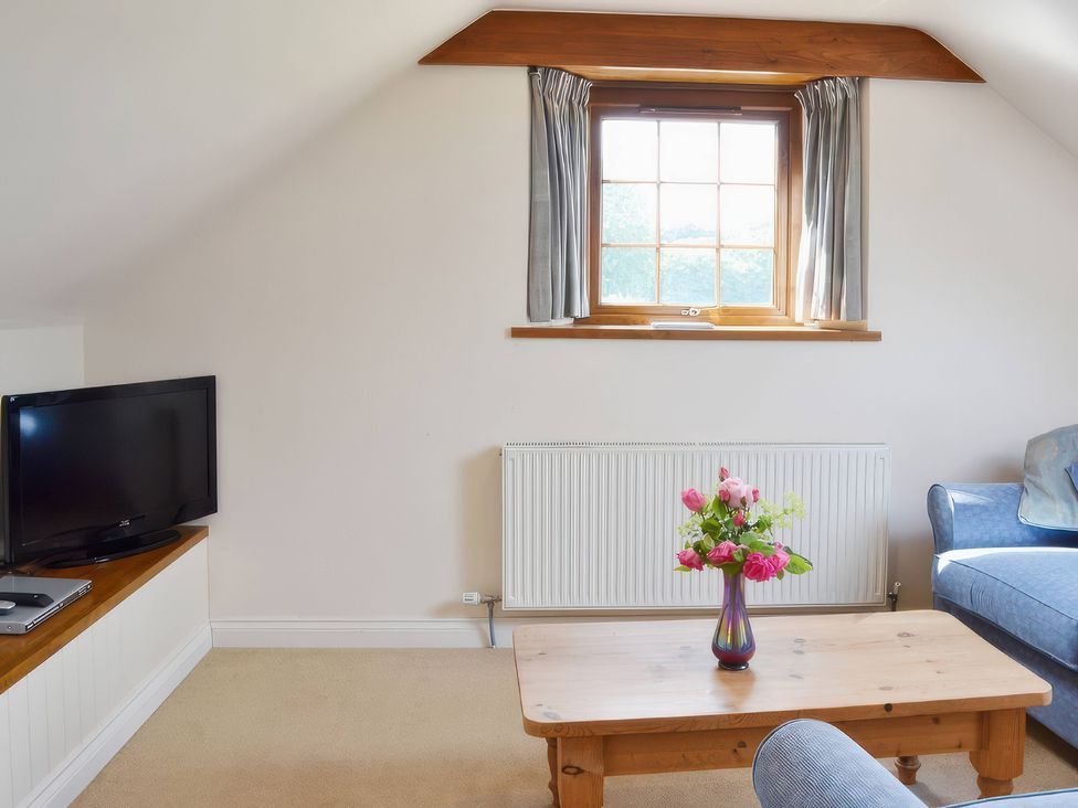 A living room with a television and coffee table at The Stables in Budock Water near Falmouth