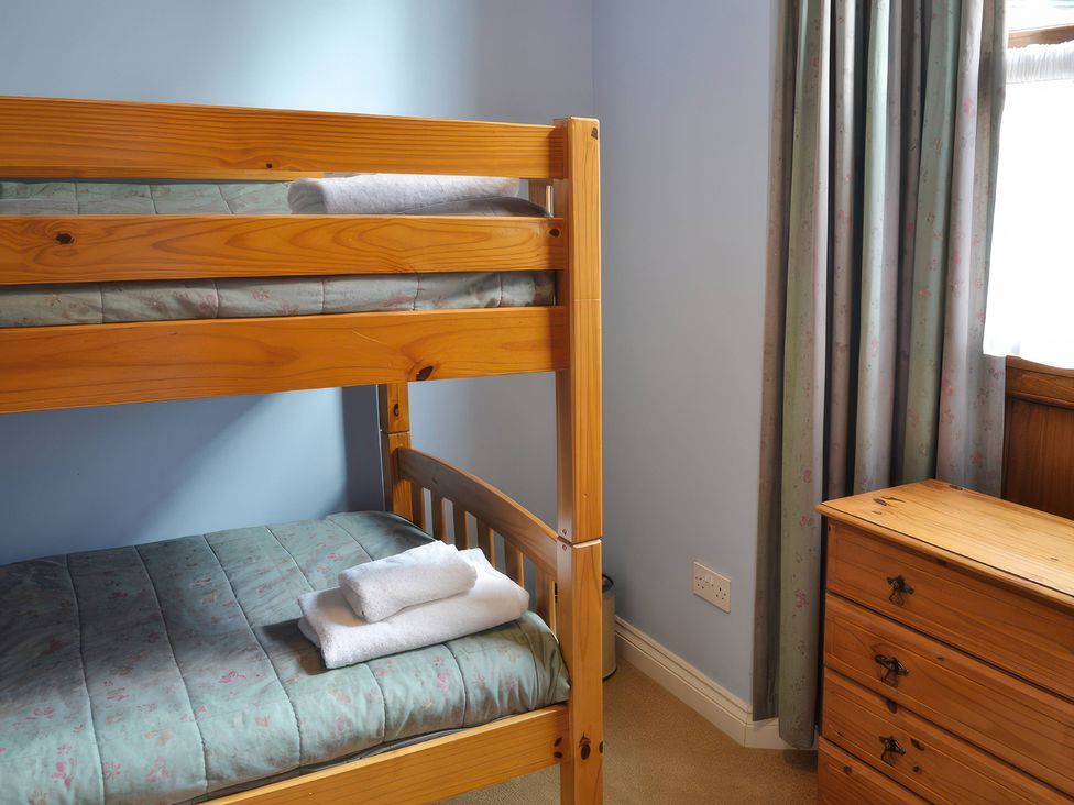 A bedroom with a bunk bed and chest of drawers at The Stables Budock Water near Falmouth