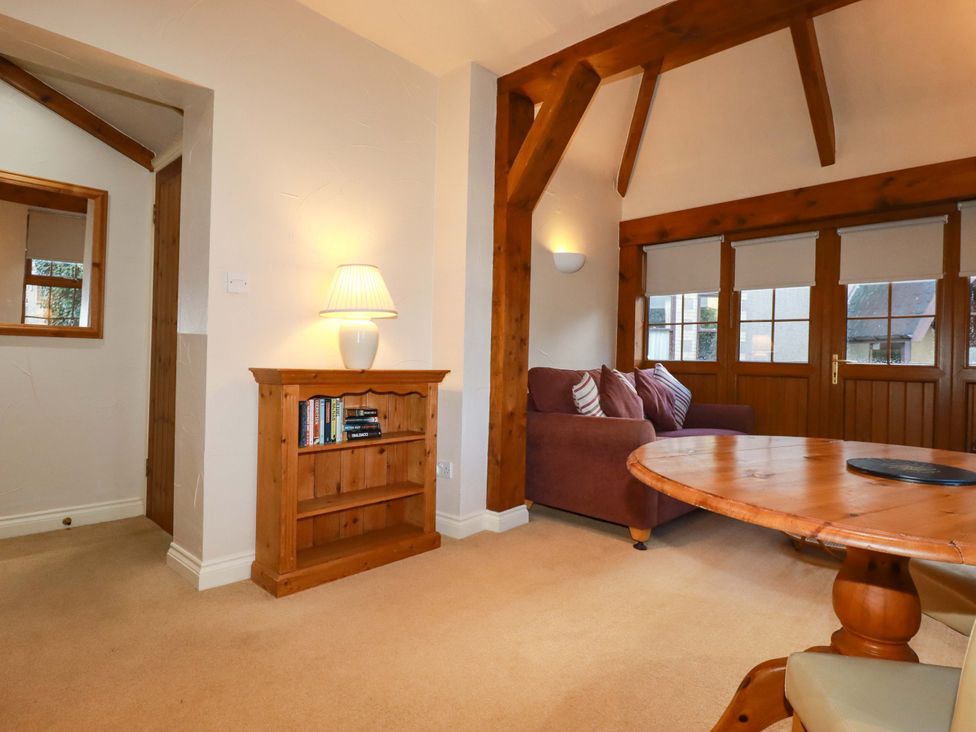 A living room with a sofa and a bookshelf at Farrier Cottage in Falmouth