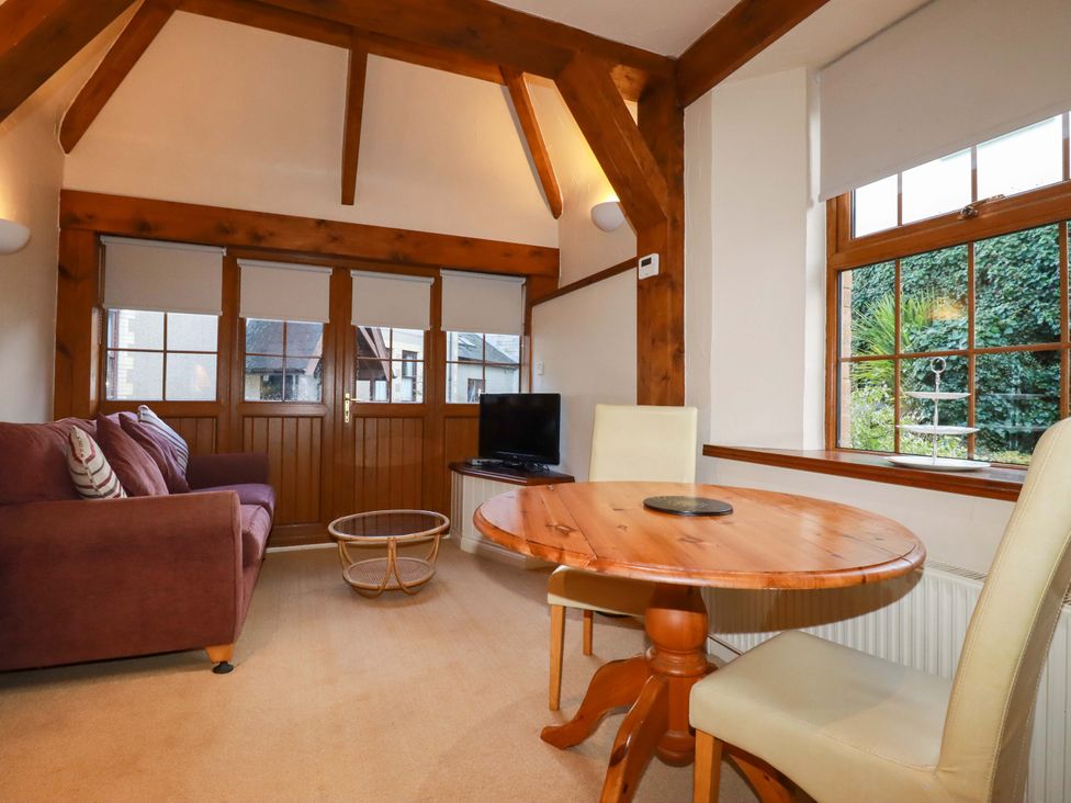 A living room with a sofa and table at Farrier Cottage in Falmouth