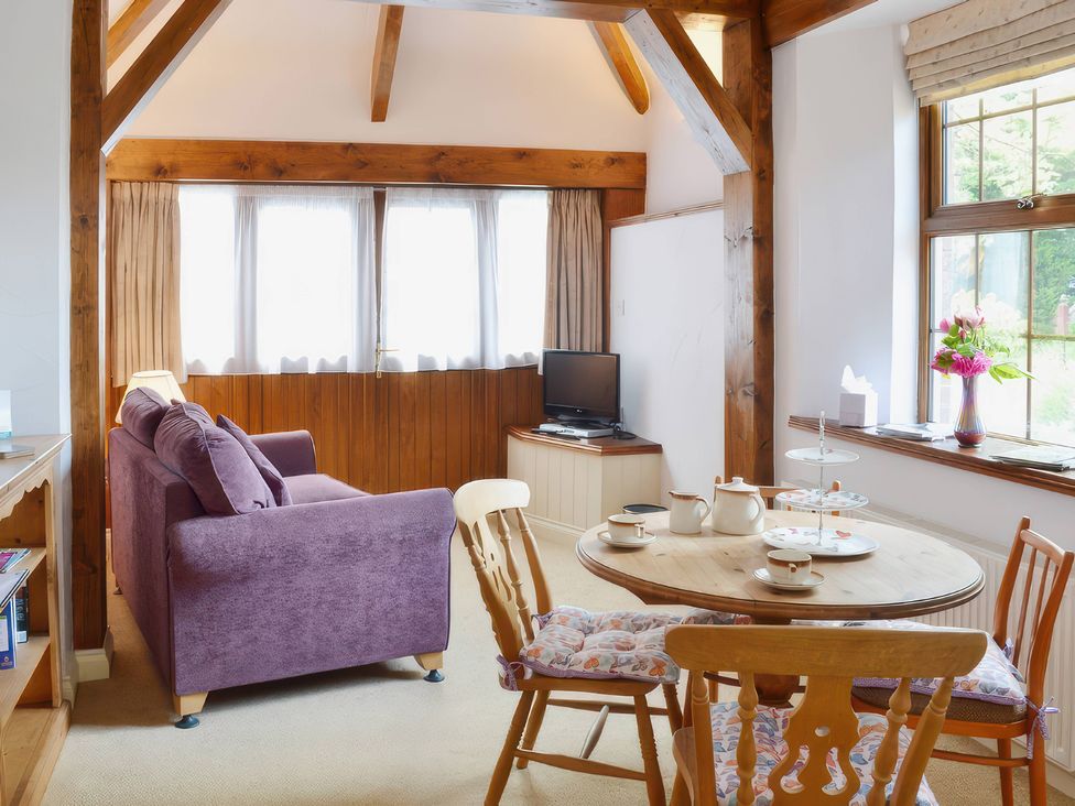 A sitting room with a sofa and table at Farrier Cottage Budock Water near Falmouth