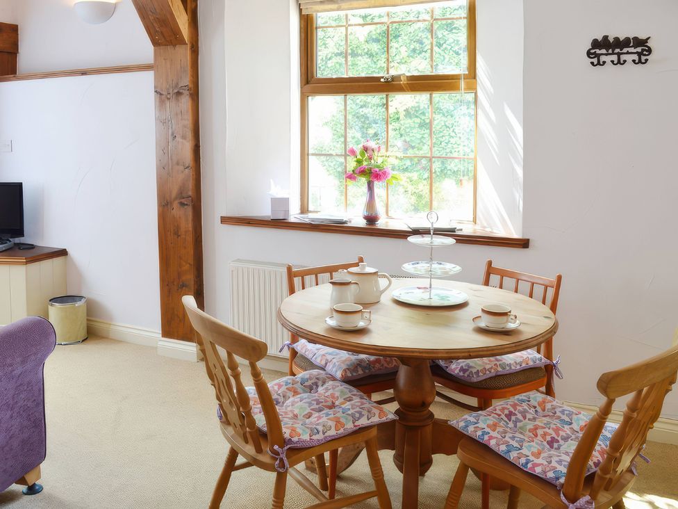 A dining room with a round table and chairs at Farrier Cottage Budock Water near Falmouth