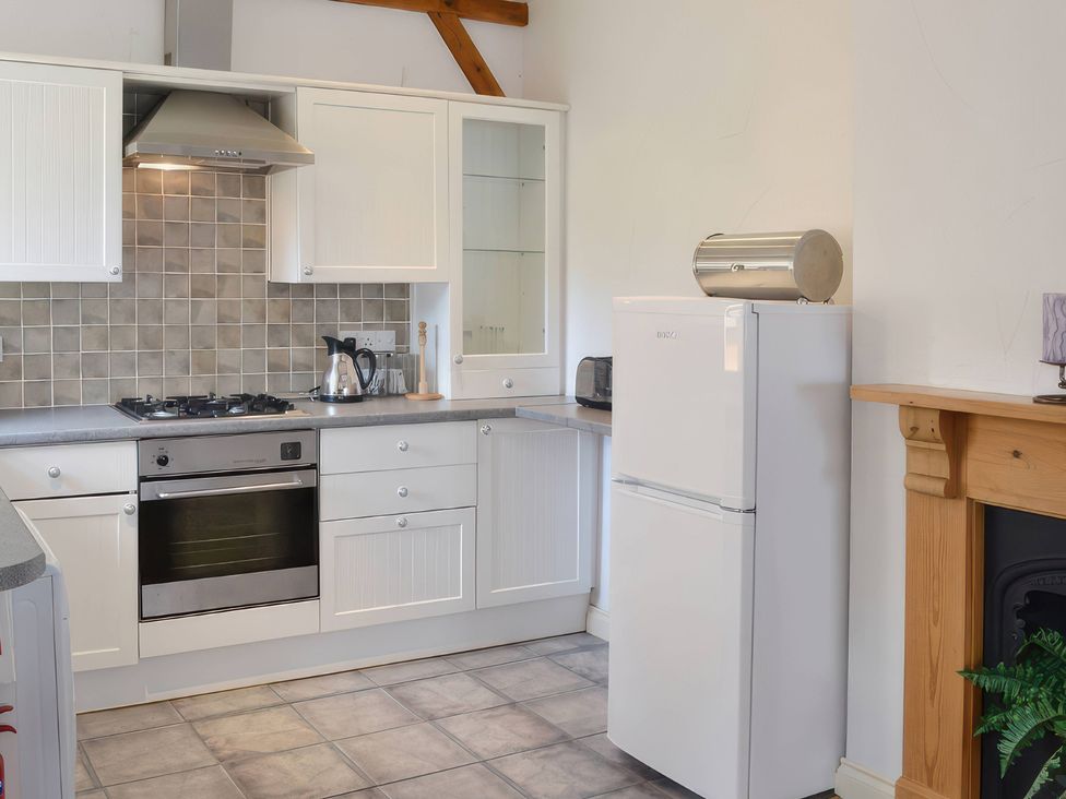 A kitchen with appliances and storage at Farrier Cottage Budock Water near Falmouth