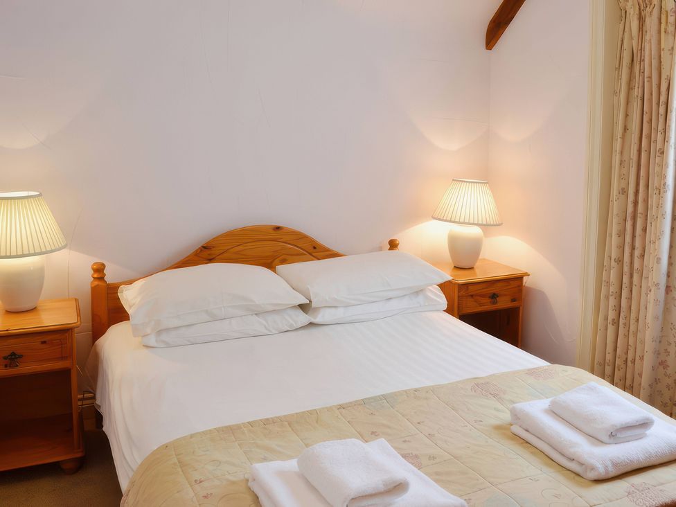 A bedroom with a bed and bedside tables at Farrier Cottage Budock Water near Falmouth