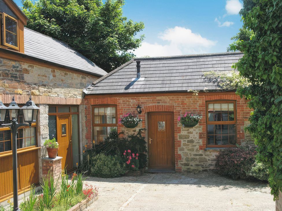 Exterior of a cottage with brick walls and plants at Farrier Cottage Budock Water near Falmouth