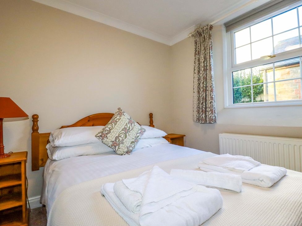 A bedroom with a bed and bedside table at Horseshoe Cottage in Falmouth