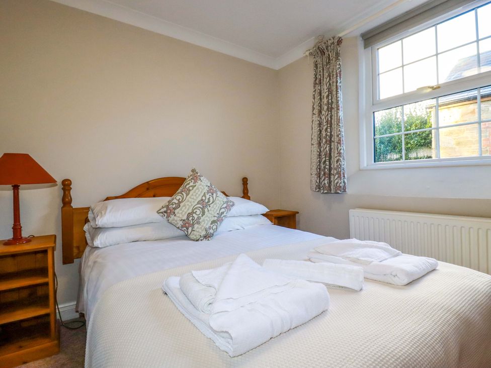 A bedroom with a bed and a bedside table at Horseshoe Cottage in Falmouth