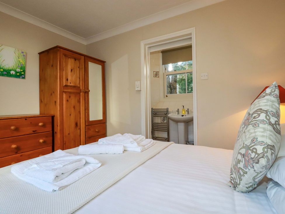 A bedroom with bed and wardrobe at Horseshoe Cottage in Falmouth