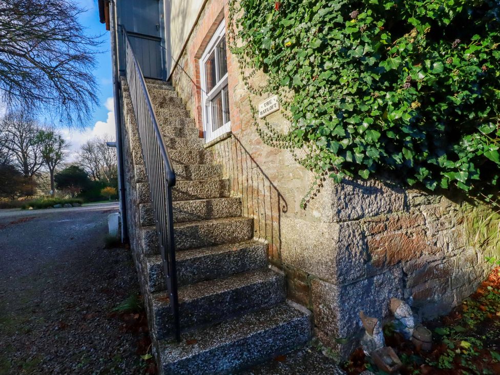 A staircase leading to a door with ivy at The Hayloft in Falmouth