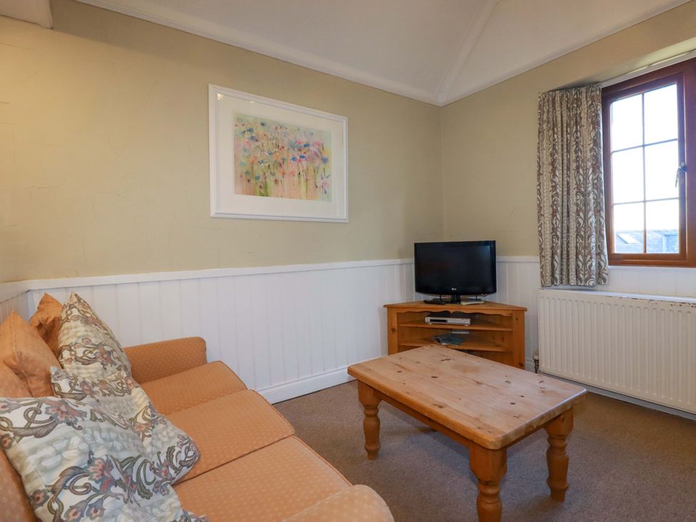 A living room with a sofa and a television at The Hayloft in Falmouth