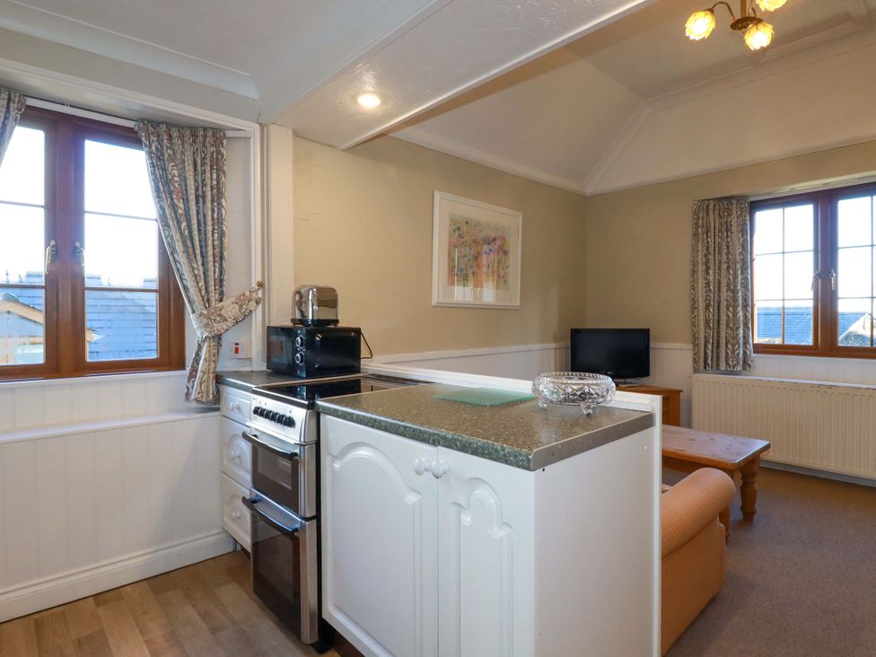A kitchen with a stove and refrigerator at The Hayloft in Falmouth