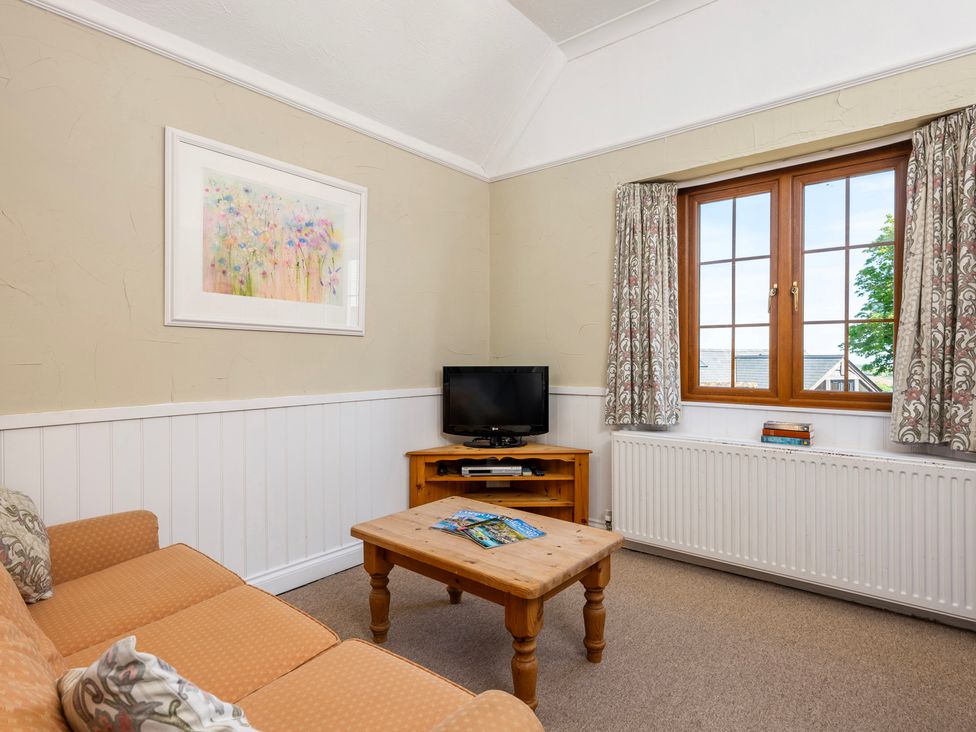 A living room with a television and coffee table at The Hayloft Budock Water near Falmouth