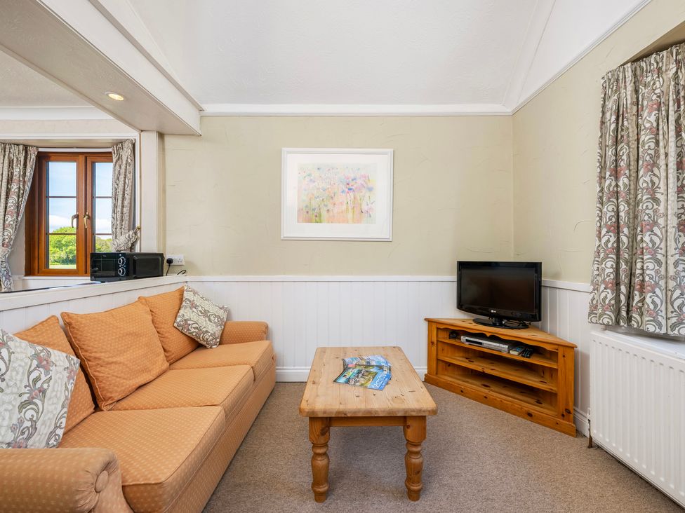 A living room with a sofa and television at The Hayloft in Budock Water near Falmouth